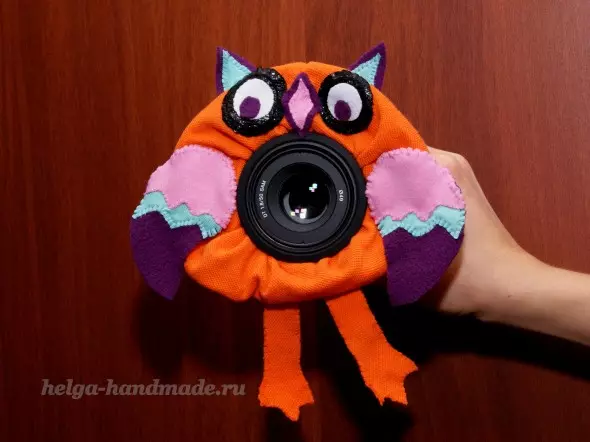 Brinquedo na lente da câmera com suas mãos crochet