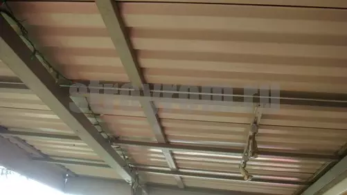 Instalación del techo hecho de pisos profesionales en un marco de metal.