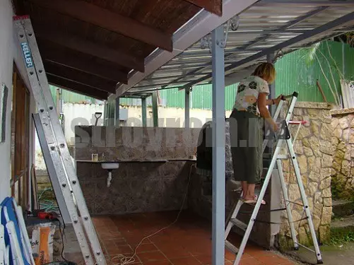 Pemasangan bumbung yang diperbuat daripada lantai profesional pada bingkai logam