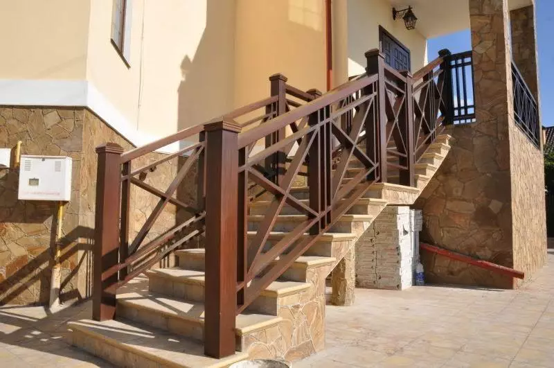 Escaleira de rúa nunha casa con barandilla de madeira