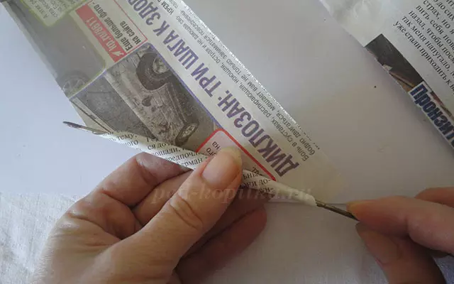 Jarrón para caramelos con las manos del papel y de los tubos de periódicos.
