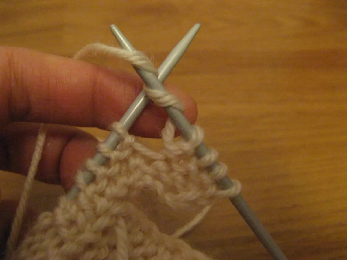 Barret d'hivern per a noies amb agulles de teixir: esquemes amb una descripció del teixit de punt de l'accessori de tardor i els HATS-HELMETS