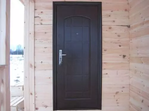 Installation de la porte d'entrée dans une maison en bois