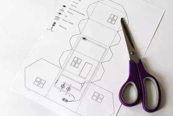 Egy papírház elrendezése saját kezével diagramokkal és fotókkal