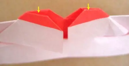 اوریگامی تکنیک میں دیوار پر اپنے ہاتھوں کے ساتھ کاغذ دل