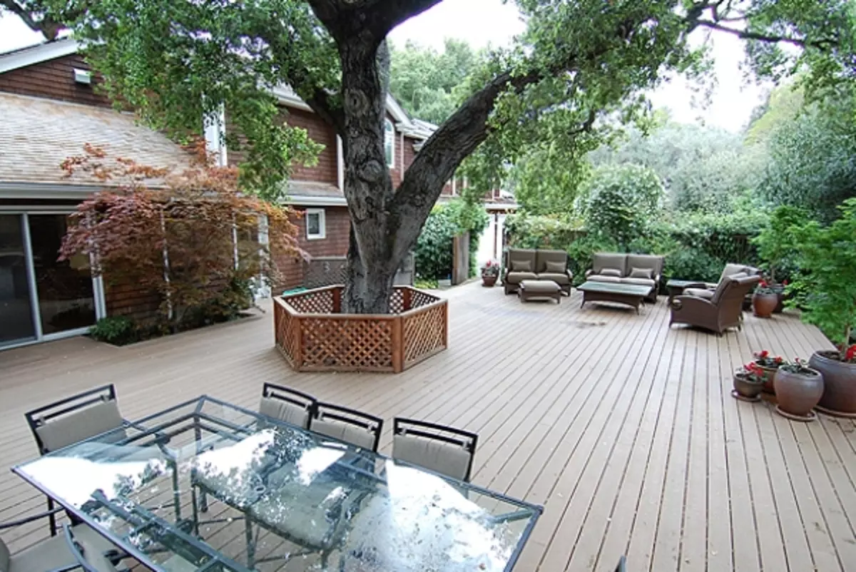 Arrangement around the tree: flowerbed, bench, table and even gazebo