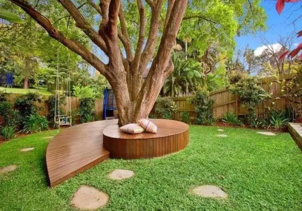 Arrangement around the tree: flowerbed, bench, table and even gazebo