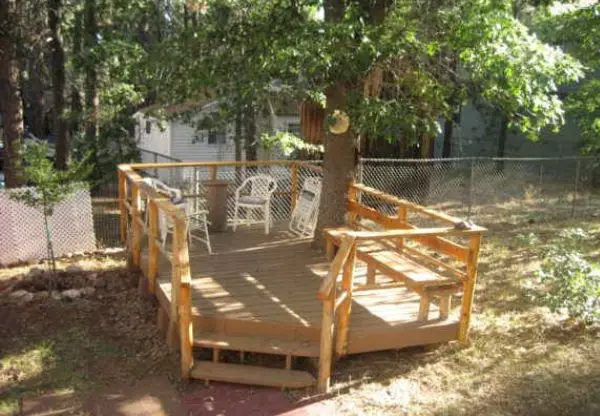 Arrangement around the tree: flowerbed, bench, table and even gazebo