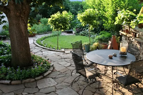 Arrangement around the tree: flowerbed, bench, table and even gazebo