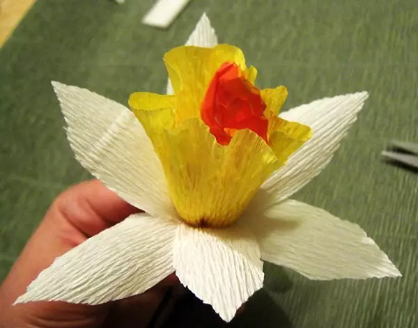 Narcissus kuchokera papepala lotetezedwa ndi manja awo omwe ali ndi maswiti