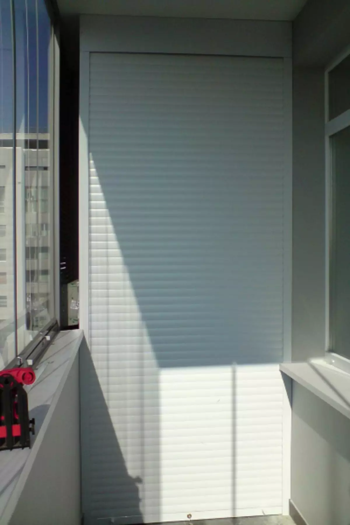Ergonomia kabineto al la balkono kun la rolo de ŝutroj: komforto kaj kompakteco