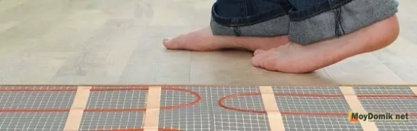 Installazione del pavimento caldo elettrico (cavo) con le loro mani